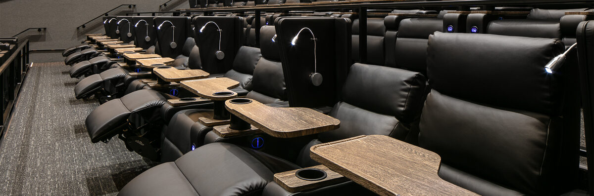 A side view of a row of dine-in cinema seating designed and installed by ES&T.